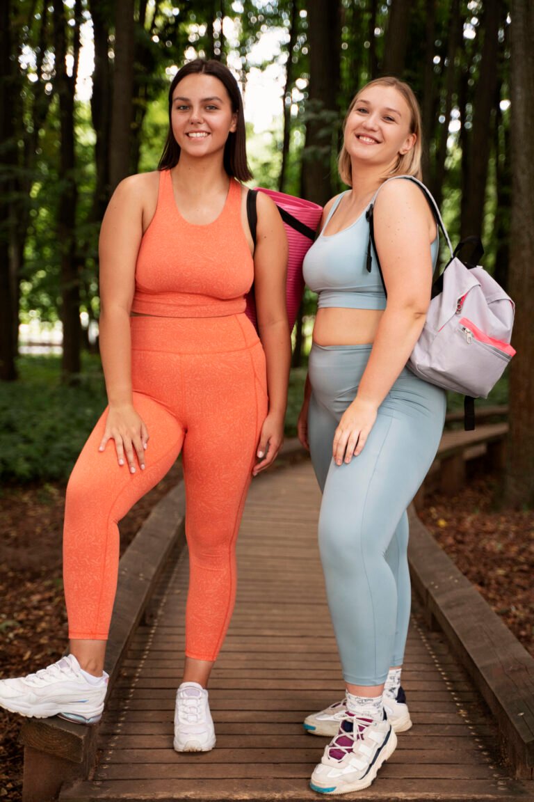 Group of women smiling and laughing together outside on a sunny day, illustrating Body Forward's wellness-focused community