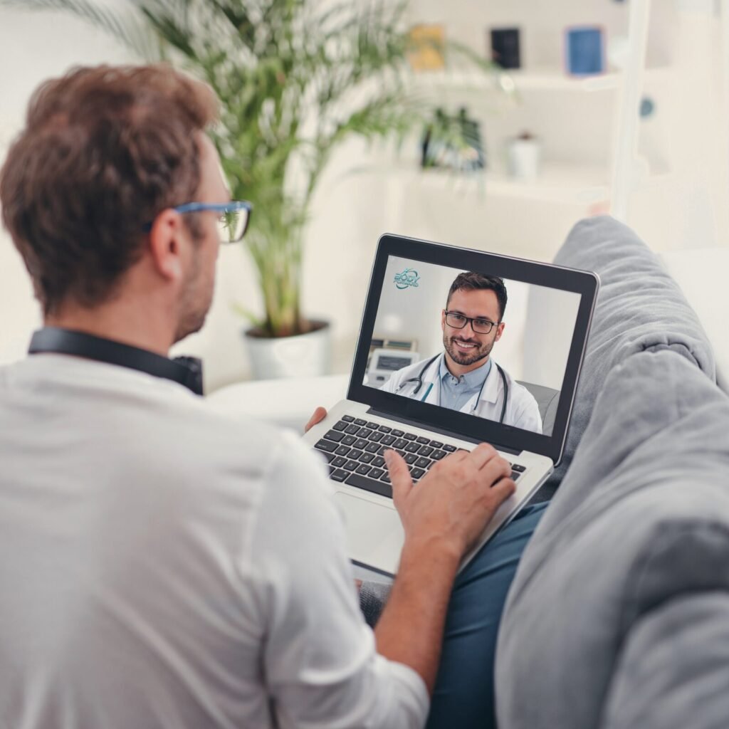 A man at home having a telehealth video consultation with a doctor on his laptop, representing a conversation with a licensed provider.
